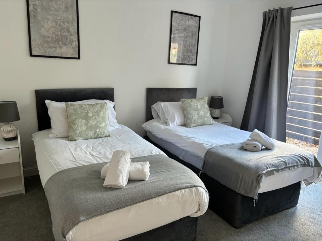 a bedroom with two beds and a window at Exquisite Long-Term Living in Cardiff's Heart in Cardiff