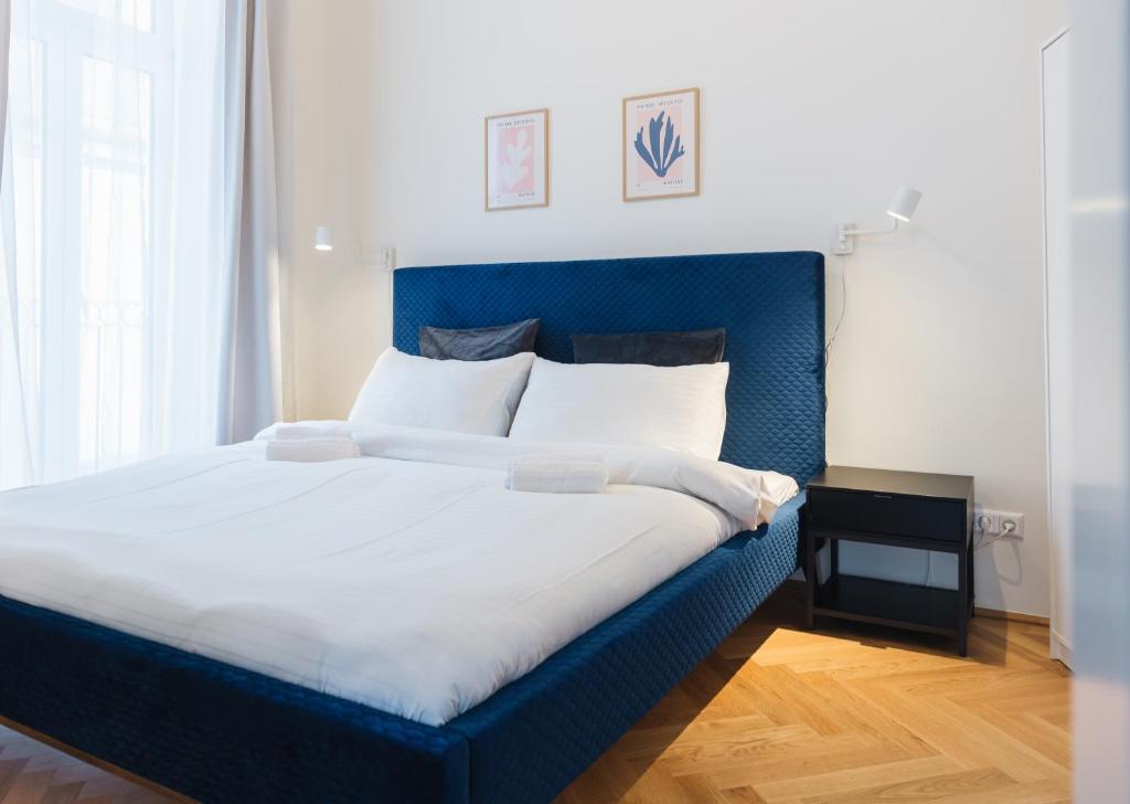 uma cama grande com uma cabeceira azul num quarto em Brand Cozy Apartment em Viena