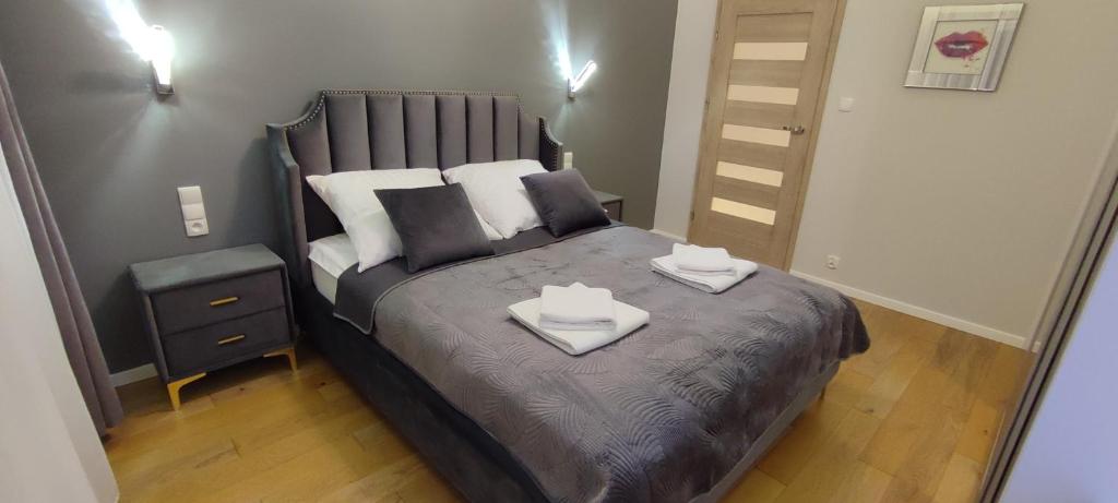 a bedroom with a bed with two towels on it at Gold Apartments Penthouse in Rzeszów