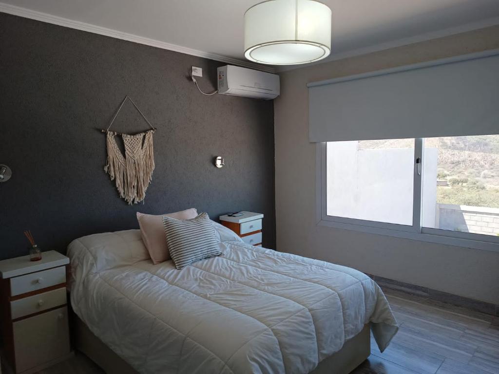 ein Schlafzimmer mit einem Bett und einem Fenster in der Unterkunft A mi manera - Casa de Sierra in Villa Giardino