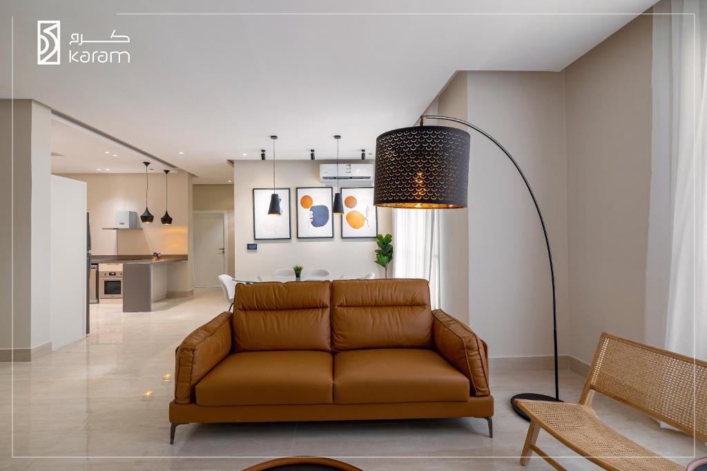 a living room with a brown couch and a floor lamp at جوهرة المغرزات Al Mugharazat jewel in Riyadh