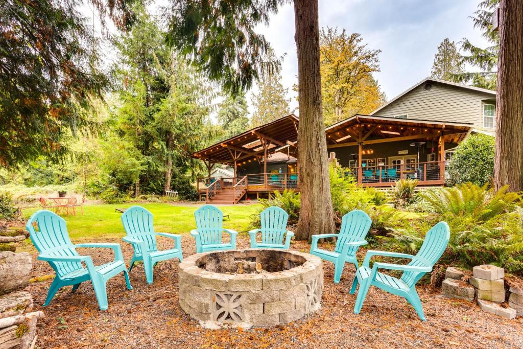 a group of chairs around a fire pit in front of a house at Peaceful Renton Retreat with Hot Tub Access! in Renton