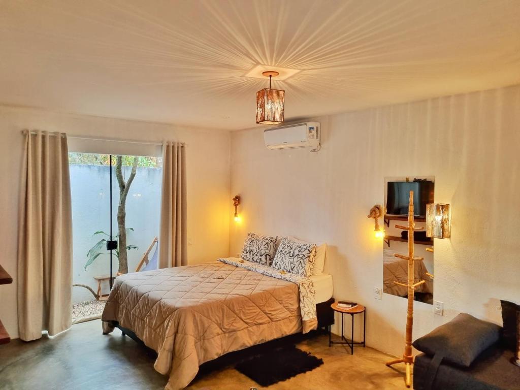 um quarto com uma cama, um sofá e uma janela em Morada dos Saguis em Alto Paraíso de Goiás