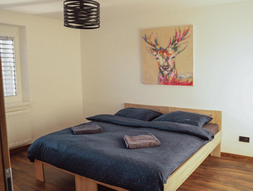 a bed in a bedroom with a painting on the wall at IQ Apartments in Prešov