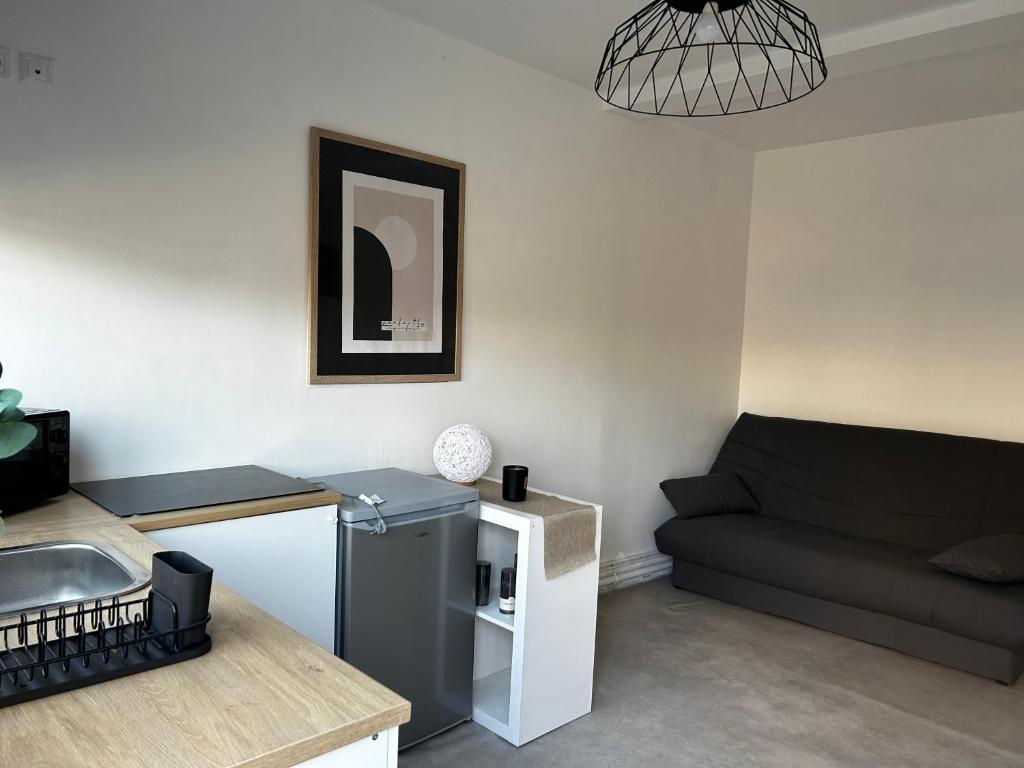 un petit salon avec un canapé et une table dans l'établissement Studio entier neuf, à Saint-Quentin