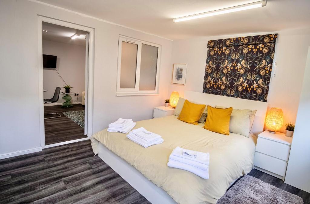 1 dormitorio con 1 cama con almohadas amarillas en Little Garden View, en Saint Albans