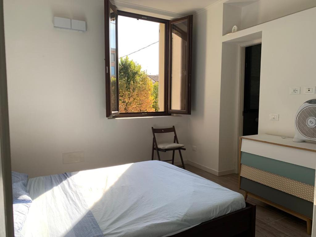 a bedroom with a bed and a window and a chair at Console Camprini Estates - Faenza Apartments 2 in Faenza