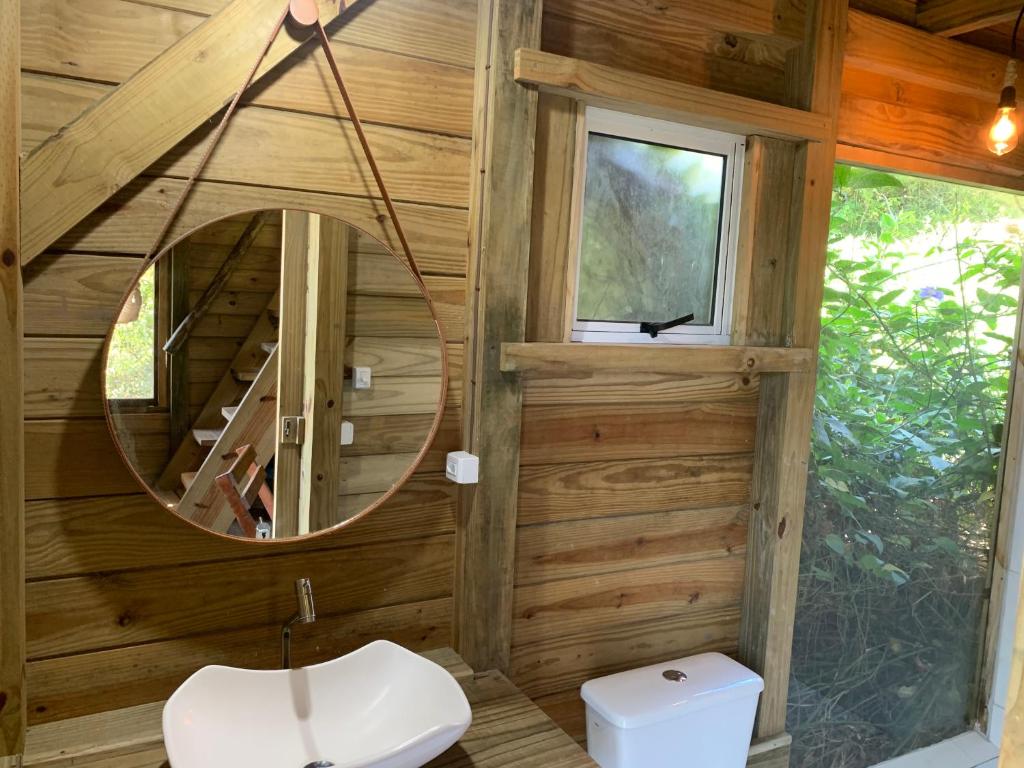 ein Bad mit einem Spiegel und einem Waschbecken im Zimmer in der Unterkunft Pousada Vale da Magia in Praia do Rosa