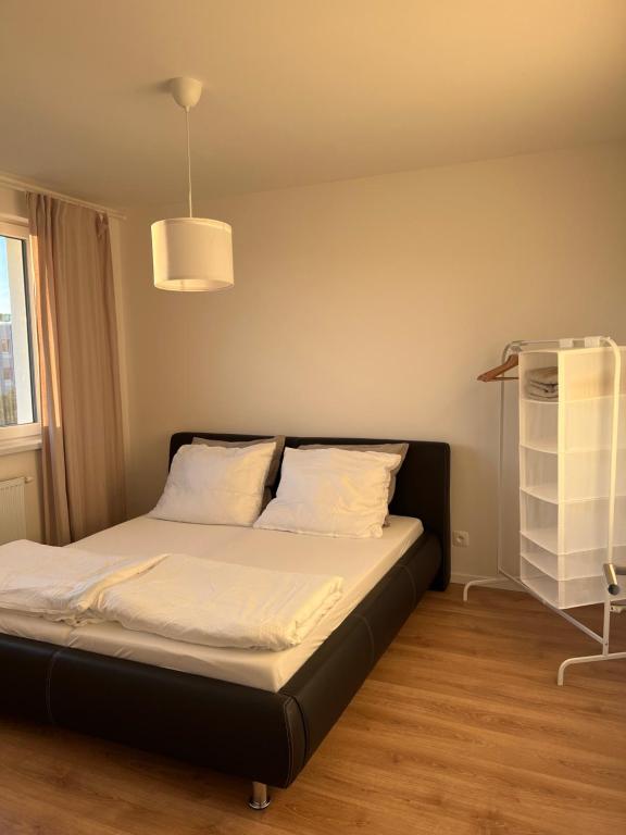 a bedroom with a bed with white sheets and a shelf at Contemporary Airport Retreat in Prievoz