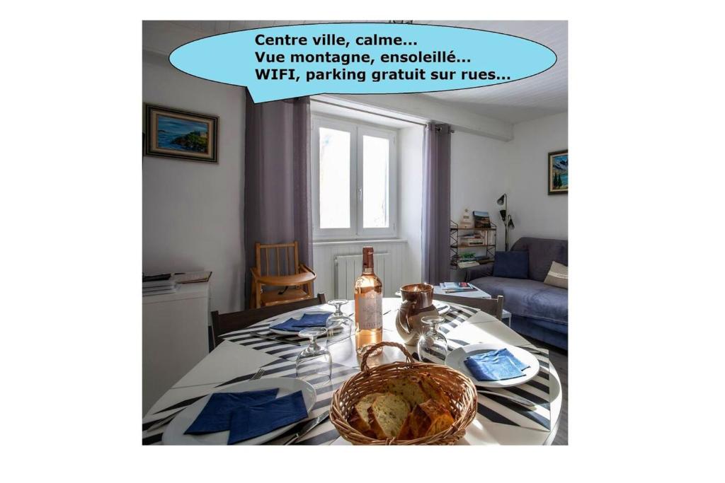 een woonkamer met een tafel met een fles erop bij Appartement d'une chambre avec vue sur la ville et wifi a Embrun in Embrun