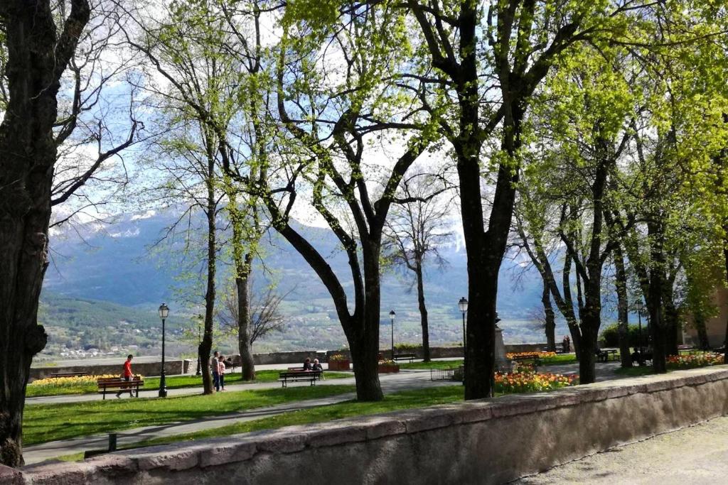 a park with trees and people sitting on benches at Appartement d&#39;une chambre avec vue sur la ville et wifi a Embrun in Embrun