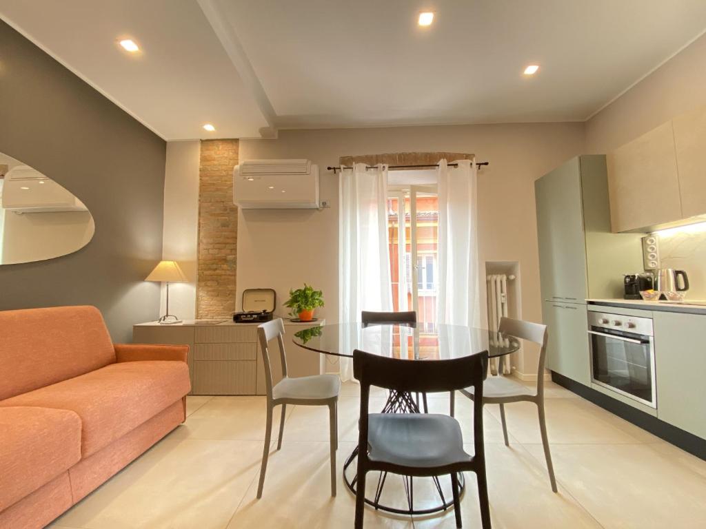 una cucina e un soggiorno con tavolo e sedie di Dimora Castelmaraldo a Modena