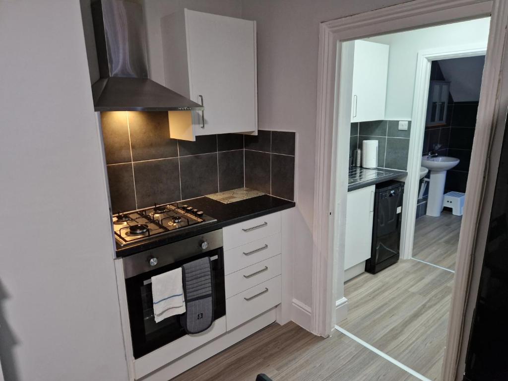 a small kitchen with a stove and a sink at Birtley's Amethyst 3 bedroom Apt sleeps 6 Guest in Birtley