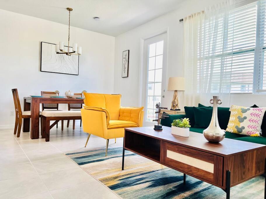 a living room with a green couch and yellow chairs at Townhouse in Champions Gate in Davenport