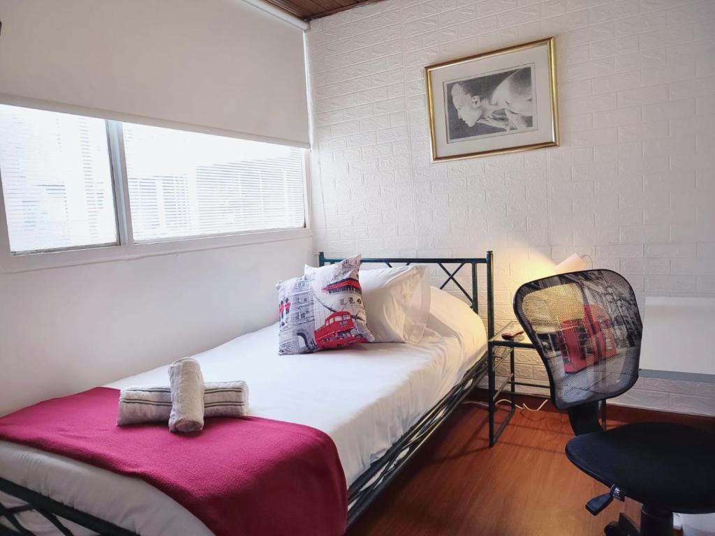 a small bedroom with a bed and a chair at Habitación sencilla con baño privado Unicentro in Bogotá