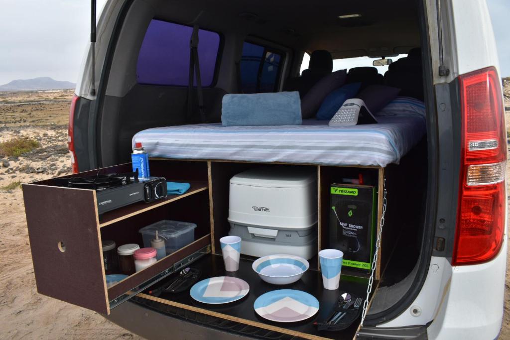 una furgoneta con cama y comida y bebidas en FurgoCamper Van H1, en Tetir