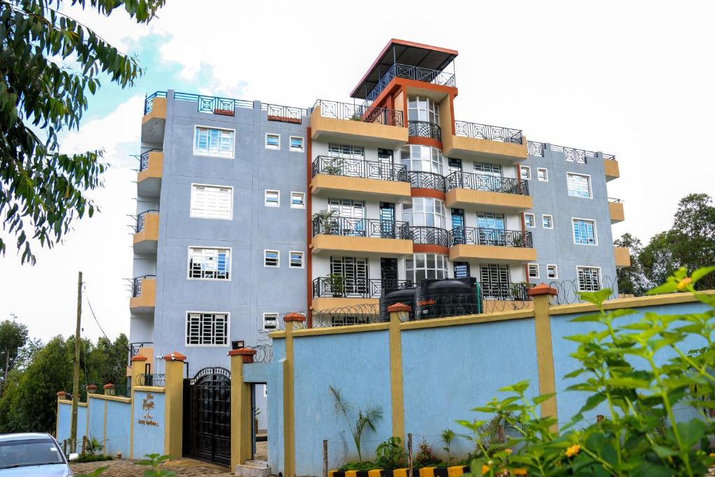 a tall gray building with balconies on top of a fence at Meru Heights in Meru