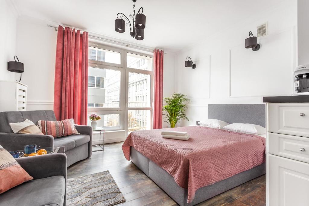 un dormitorio con una cama y un sofá en Charming Apartment in the City Center, en Varsovia