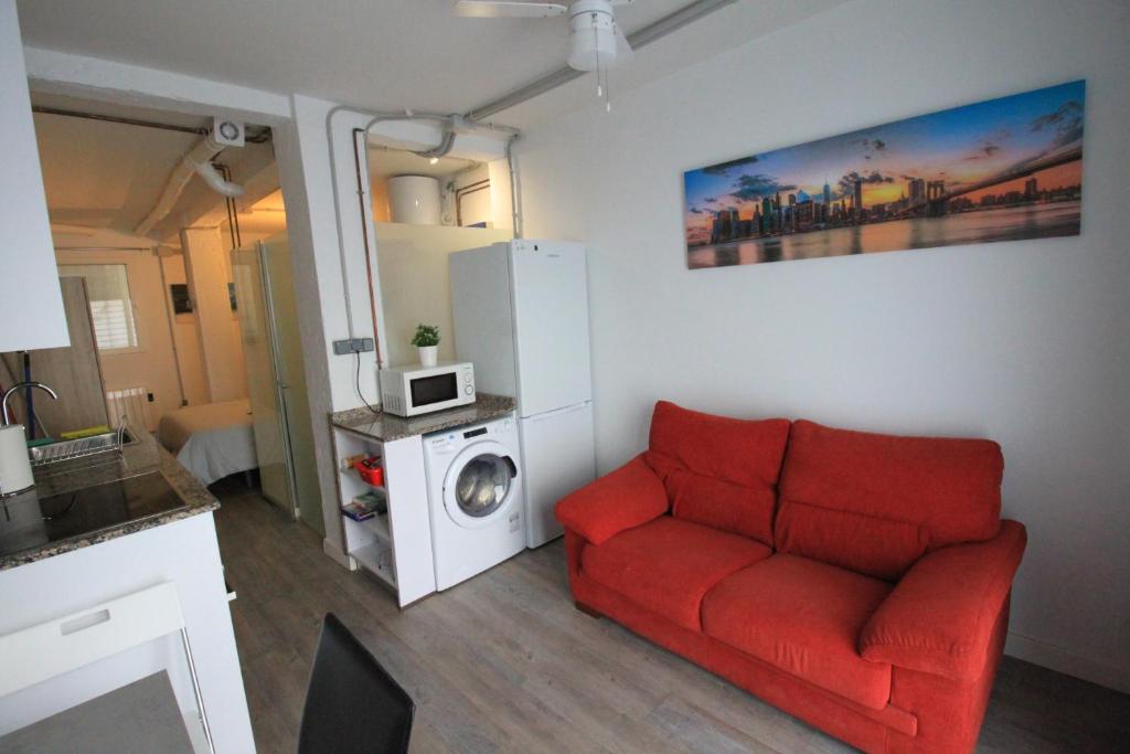 uma sala de estar com um sofá vermelho e uma máquina de lavar roupa em La Casita de Vicálvaro em Madri