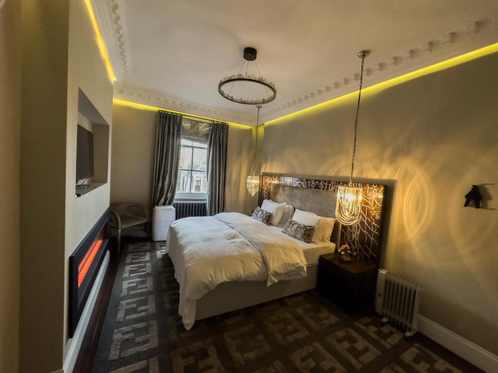 a hotel room with a bed and a tv at Luxury 3 beds Palace Gate Kesington in London