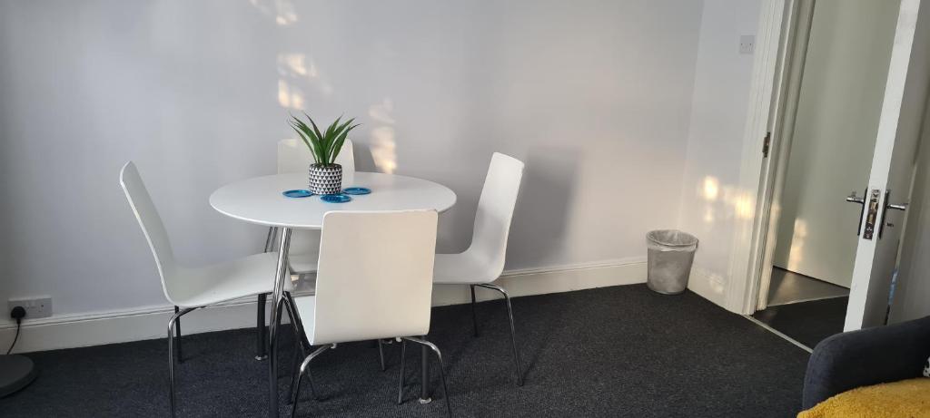 a white table with white chairs and a plant on it at 2 Bed Flat North London in Edmonton
