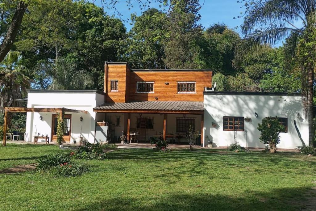 uma casa com um edifício branco e um quintal em CASA ZORZAL Casaquinta en El Cazador em Belén de Escobar