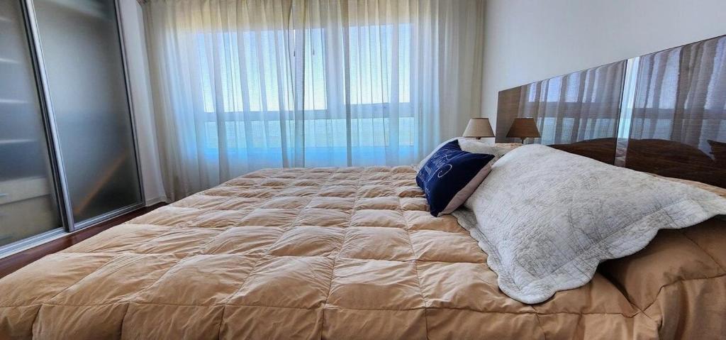 a bedroom with a large bed with a large window at Puerto Madero Piso 20 Vista al Rio frente a Hilton in Buenos Aires