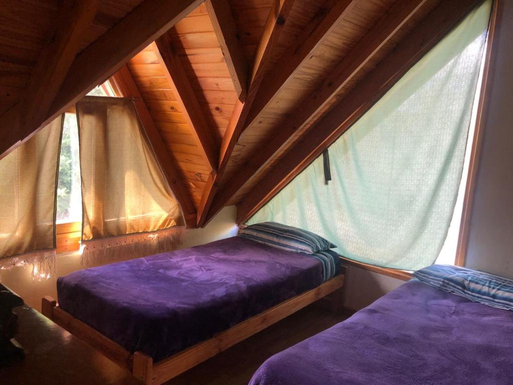 1 Schlafzimmer mit 2 Betten in einem Zimmer mit Fenstern in der Unterkunft El Tranco - Casa "Bajada Poujardieu" in Junín de los Andes