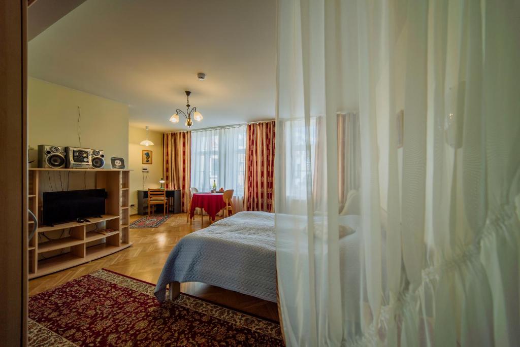 a bedroom with a bed and a television in a room at Romeo Family Uus Apartments in Tallinn