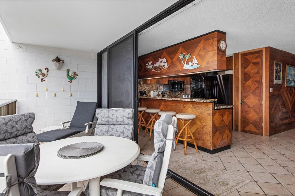 Il comprend un salon avec une table et une cuisine. dans l'établissement Maui Parkshore 209 - MCH, à Kihei