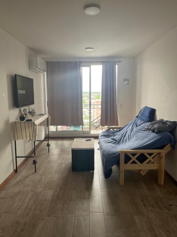 1 dormitorio con cama, escritorio y ventana en Dpto zona céntrica con yacuzzi en San Lorenzo