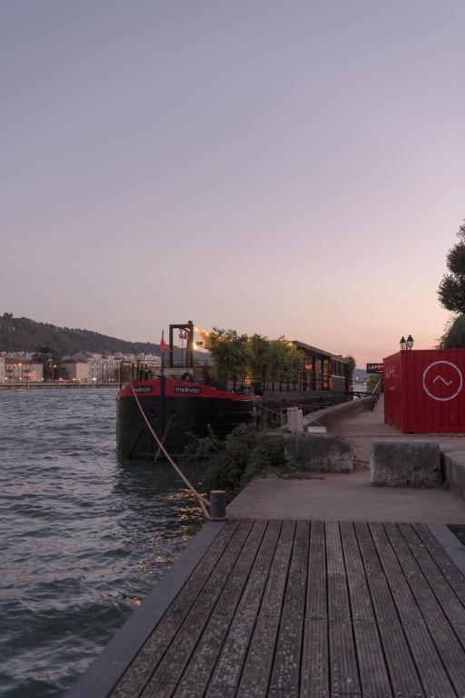 un barco está atracado en un muelle sobre el agua en LA PENICHE - Bed And Bicycle - Vienne, en Vienne