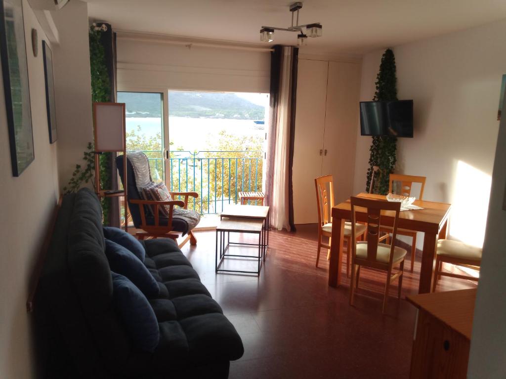 uma sala de estar com um sofá, uma mesa e cadeiras em Artmony piso centro del pueblo vista frente al mar appartement plein centre en front de mer em Port de la Selva