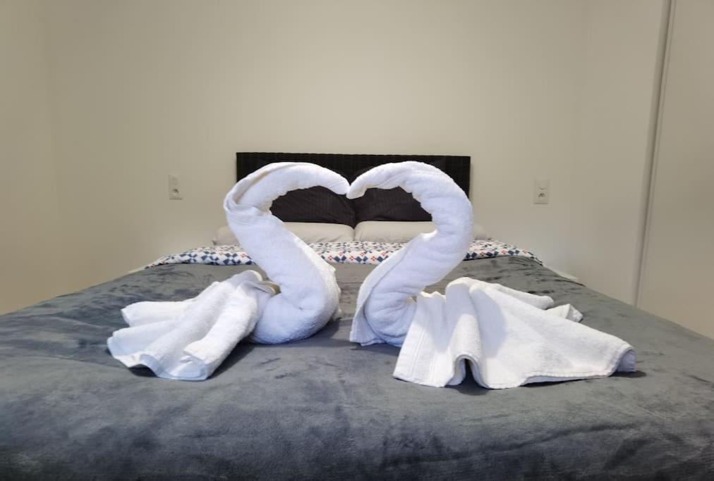 una cama con dos cisnes hechos de toallas en Maison Disney, Paris, Val d'Europe en Quincy-Voisins