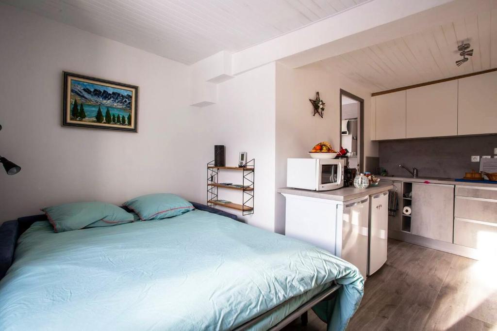 a bedroom with a blue bed and a kitchen at Appartement d&#39;une chambre avec vue sur la ville et wifi a Embrun in Embrun