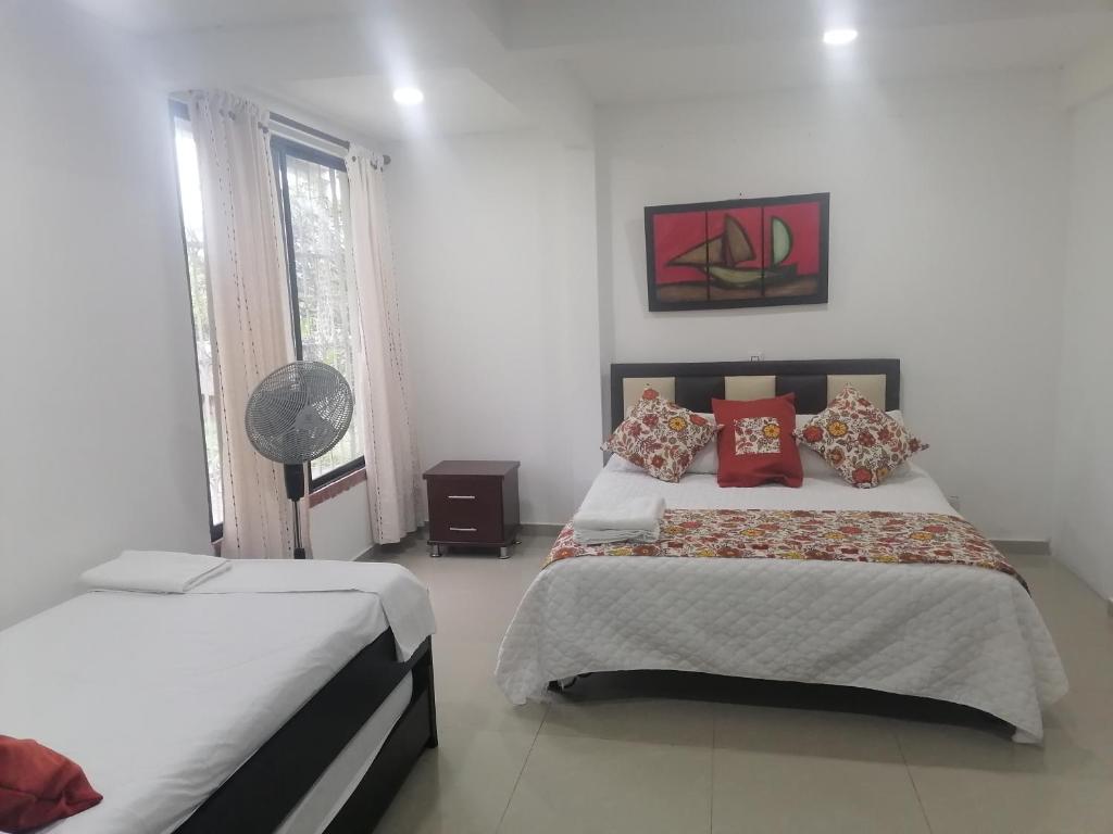 1 dormitorio blanco con 2 camas y ventana en Apartamento Campestre Pereira, en Pereira