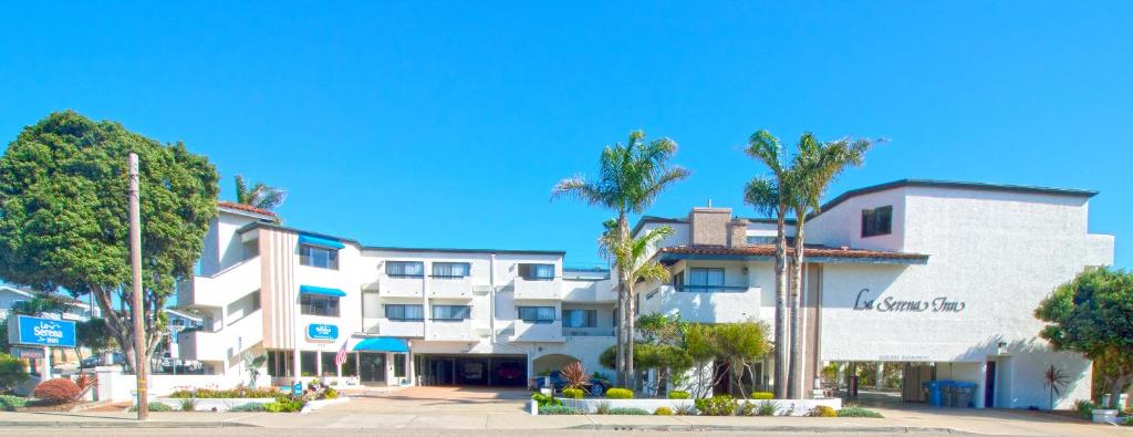 um edifício branco com palmeiras em frente em La Serena Inn em Morro Bay