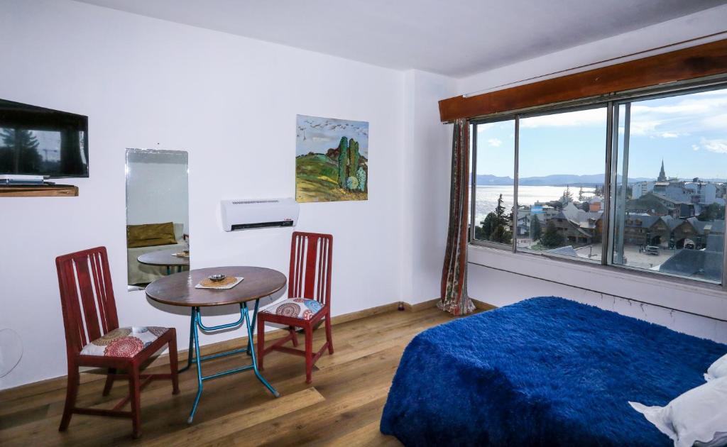 1 dormitorio con 1 cama, mesa y sillas en Center Bariloche en San Carlos de Bariloche