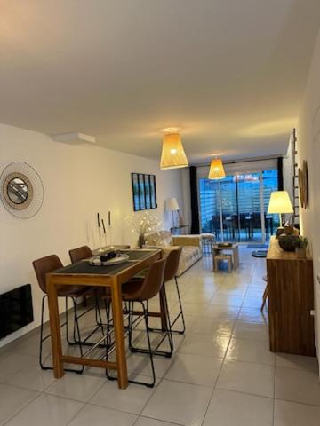 une cuisine avec une table et des chaises dans une pièce dans l'établissement Le brise lame maison neuve à 2 pas de la plage, à Le Portel