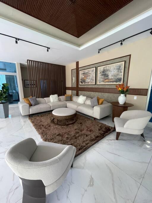 - un salon avec des canapés, des chaises et un tapis dans l'établissement Moderno apartamento en Naco, à Saint-Domingue