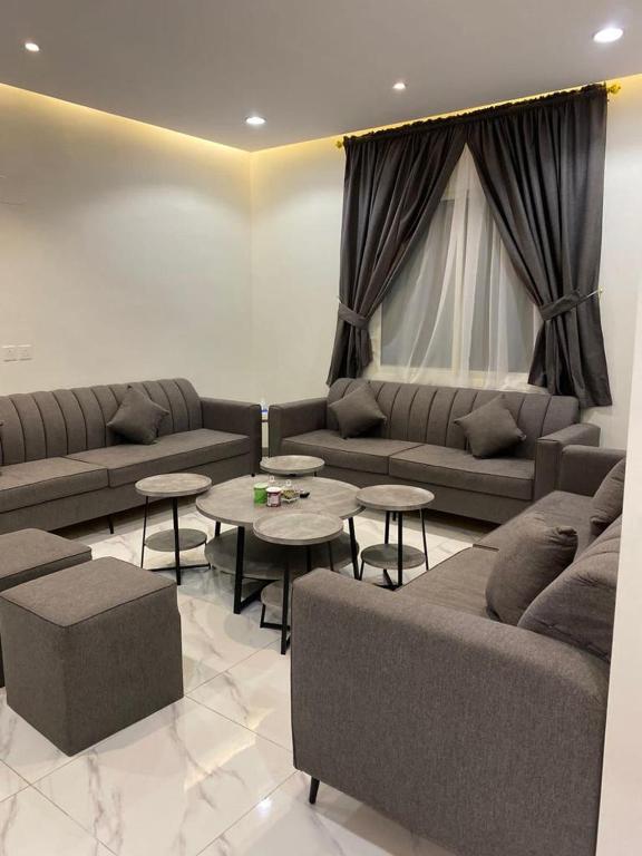 uma sala de estar com sofás e mesas num quarto em وناسه مودرن em Riyadh