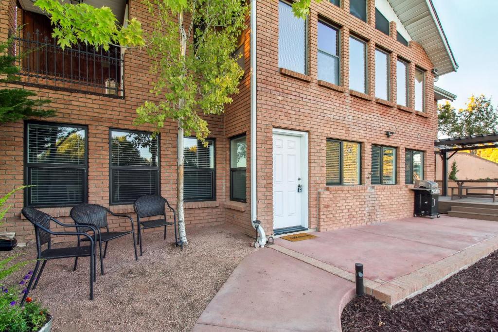 un edificio de ladrillo con sillas y una mesa frente a él en Patio, Grill and Fire Pit Show Low Escape!, en Show Low