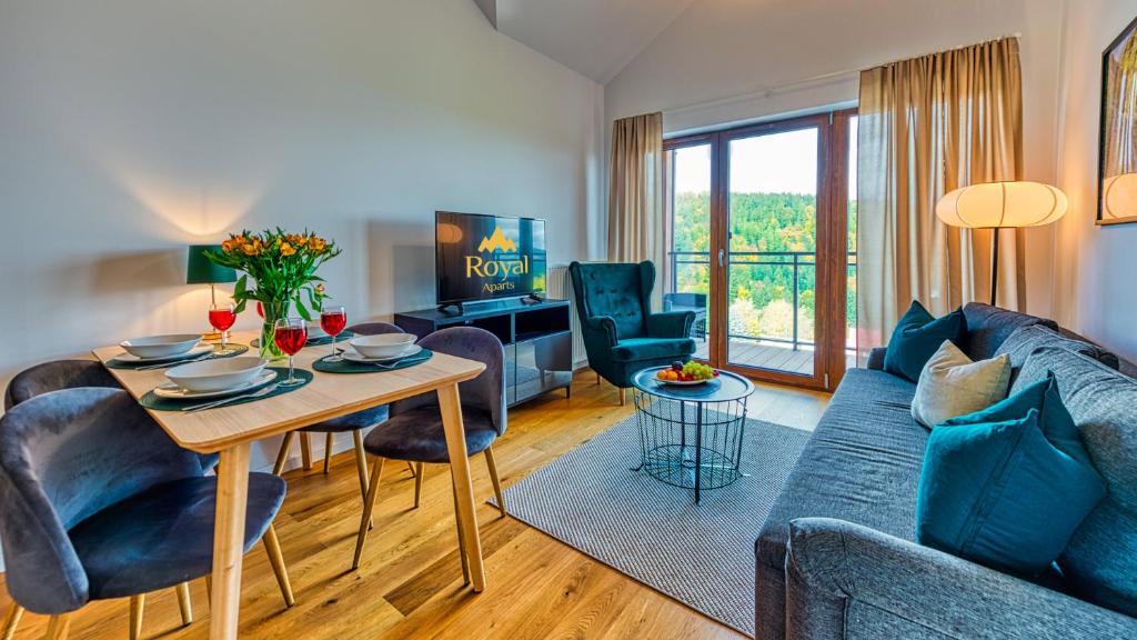 a living room with a couch and a table at Apartamenty Karpatia Resort by ROYAL APARTS in Karpacz