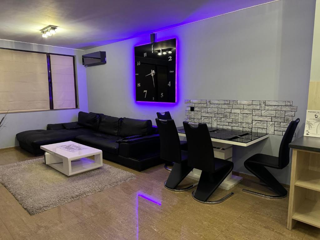 ein Wohnzimmer mit einem Sofa und einer Uhr an der Wand in der Unterkunft Apartments Las Tres Palmas in Sofia