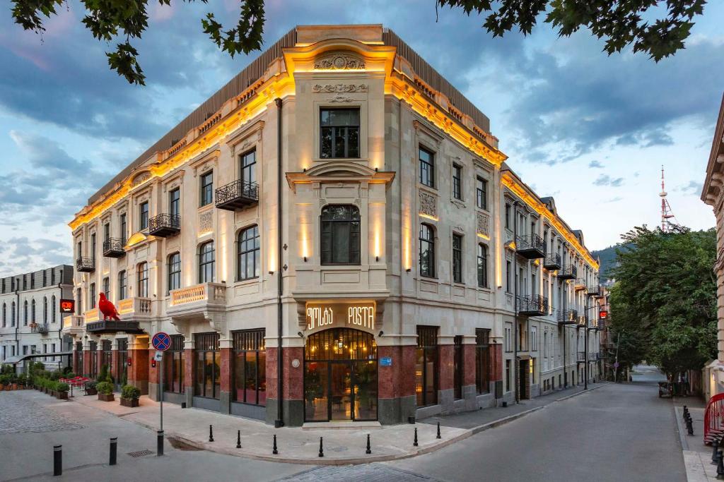 a large white building on a city street at Radisson RED Tbilisi in Tbilisi City