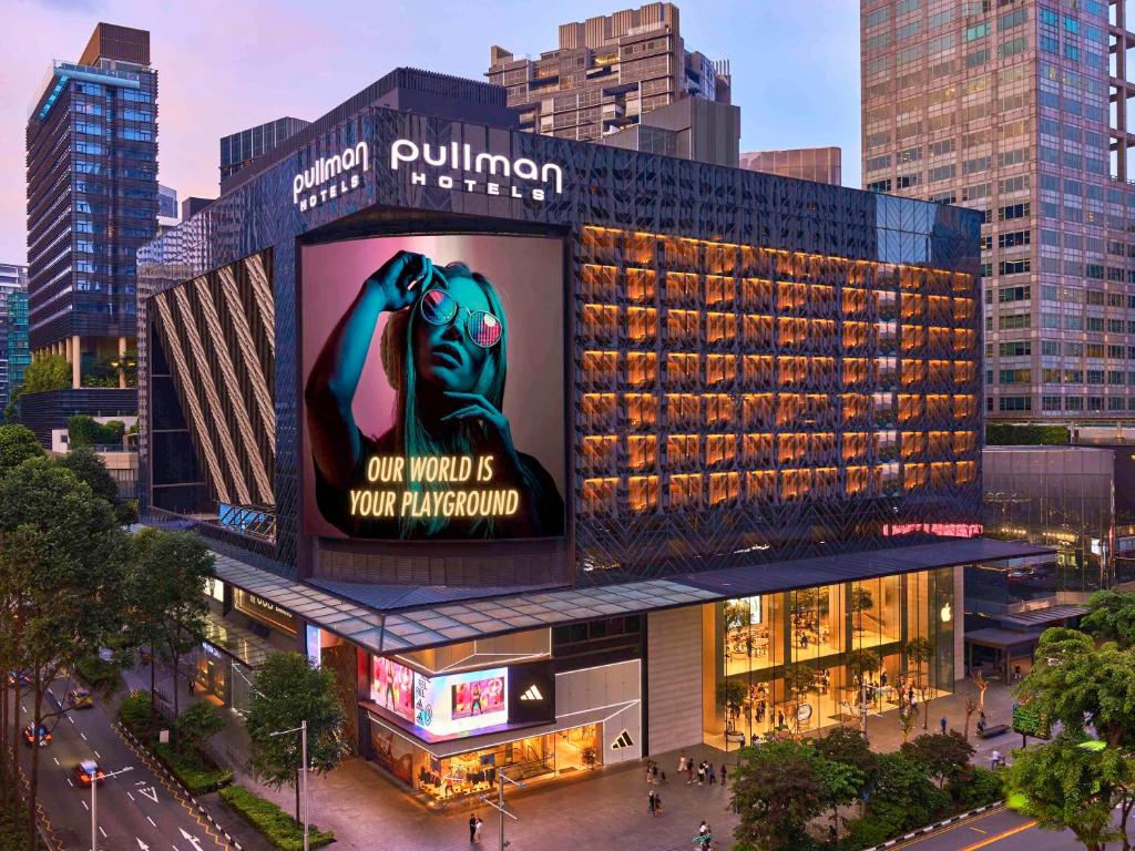 a building with a sign that reads our world is your kingdom at Pullman Singapore Orchard in Singapore