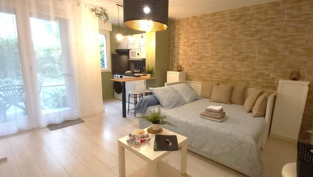 un soggiorno con divano e tavolo di Les Elfes - avec entrée autonome, jardin, parking privé & gourmandises offertes ! - a Tolosa