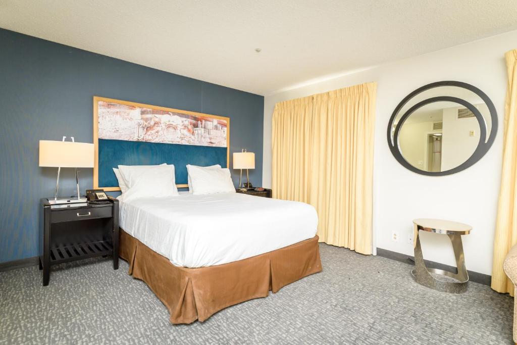 a bedroom with a large bed and a mirror at Philadelphia Suites at Airport - An Extended Stay Hotel in Philadelphia