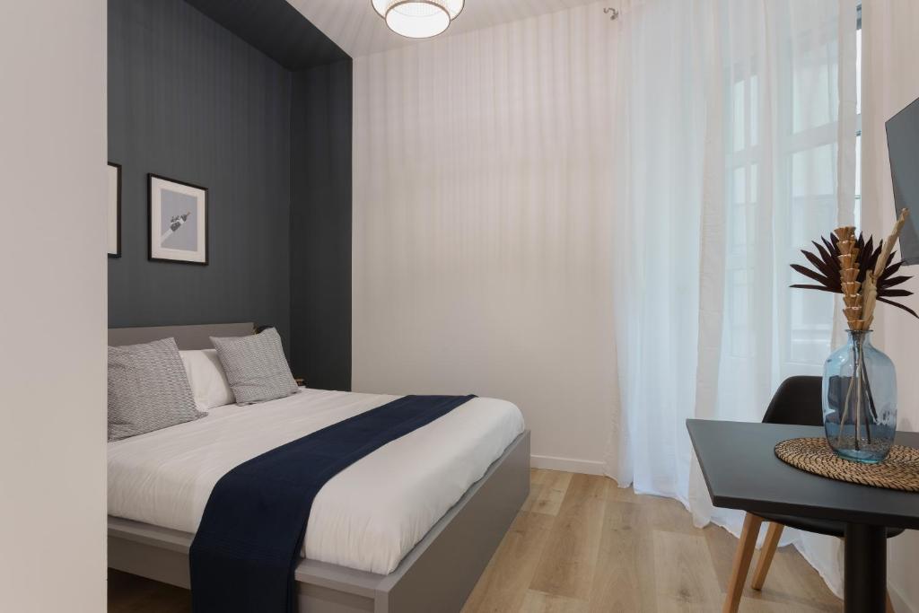 een slaapkamer met een bed, een tafel en een raam bij Central Trieste Marvel studio in Trieste