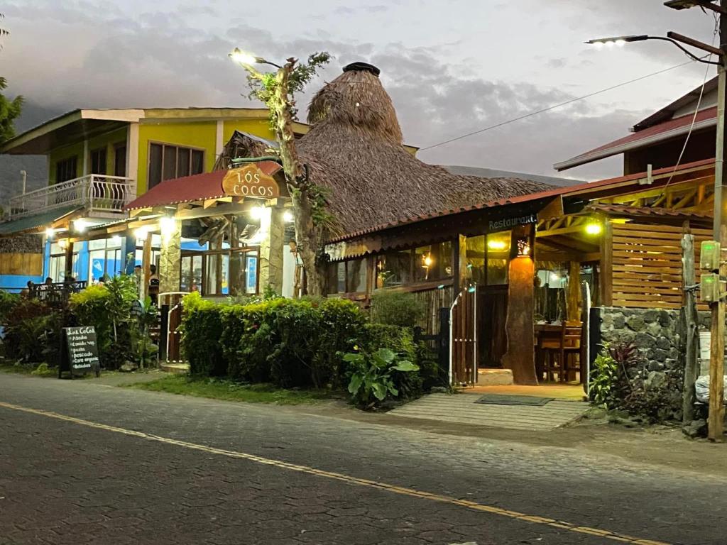 a building with a thatched roof on a street at Hotel Restaurante Los Cocos in Santa Cruz